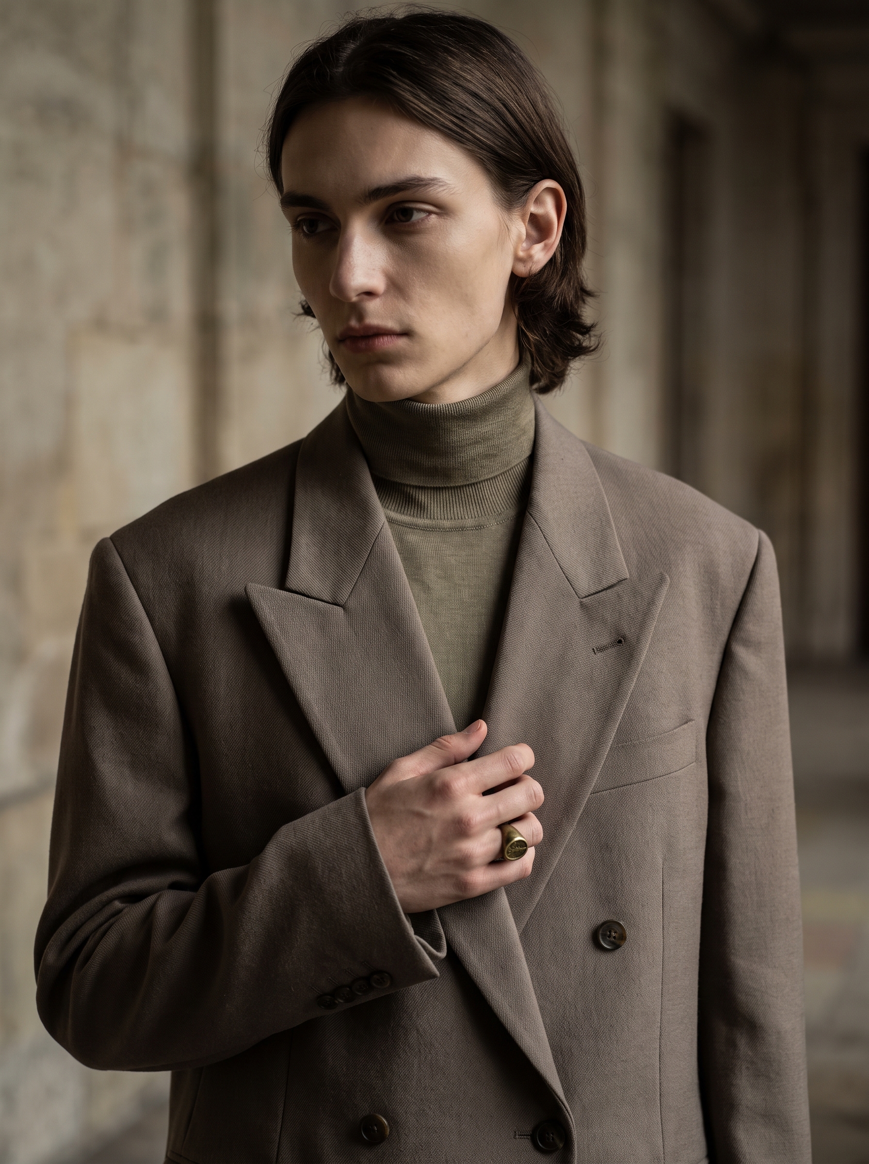 Waist-up portrait highlighting the tailored blazer lapels and olive silk turtleneck.